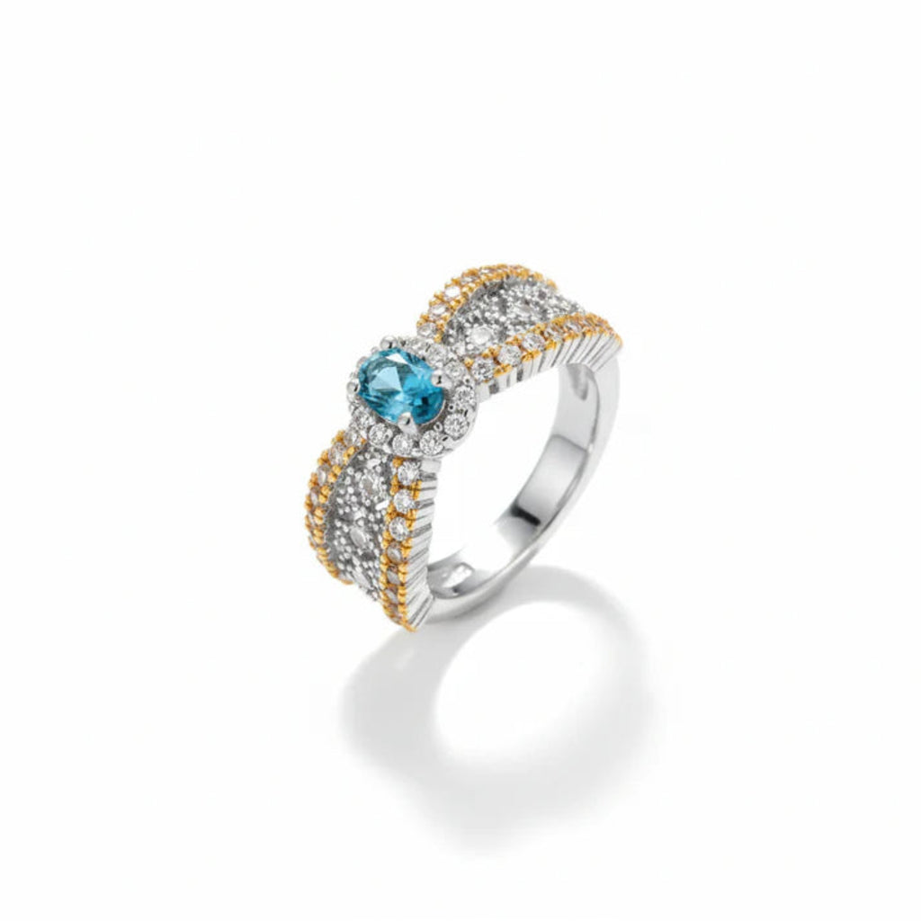 Silver ring with blue gemstone and gold accents on a white background