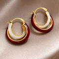 Pair of gold hoop earrings with red and white circular accents 